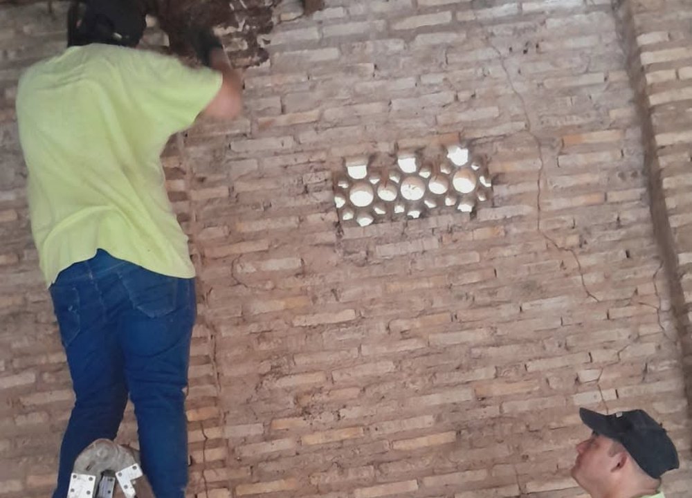 Trabajo en altura con escalera para tratar un foco en la pared